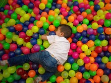 High Angle View Of Boy Over Multi Colored Balls