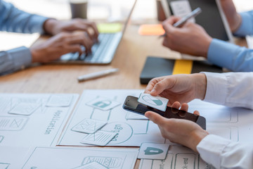 mobile application designers and website designers brainstorm and planning project work together.