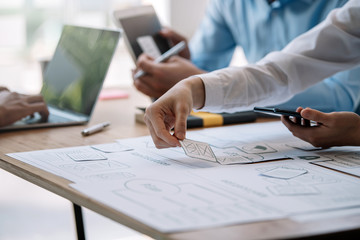 mobile application designers and website designers brainstorm and planning project work together.