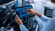 © Gorodenkoff - Car Service Manager or Mechanic Uses a Tablet Computer with a Futuristic Interactive Diagnostics Software. Specialist Inspecting the Vehicle in Order to Find Broken Components In the Engine Bay.