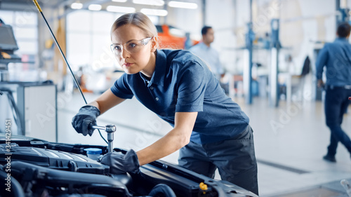 Fotografía Beautiful Empowering Female Mechanic is Working on a Car in a Car Service