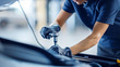 © Gorodenkoff - Close Up Shot of a Female Mechanic Working on a Car in a Car Service. Empowering Woman Makes an Usual Car Maintenance. She's Using a Ratchet. Modern Clean Workshop.