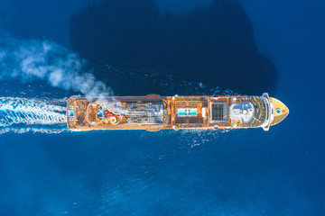 Wall Mural - Cruise ship with smoke and shadow in the turquoise sea, with a glare from the sun on the water. Concept of summer sea cruise tours.