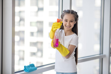 Cheerful teenager girl with detergent in her hands.