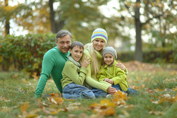 Wall Mural - Happy smiling family relaxing in autumn forest