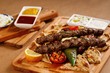 Savory lamb kebab served with pita bread and grilled cherry tomatoes.. Authentic greek cuisine in presentable plating. Mediterranean cuisine main course photography.