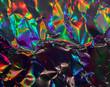 © Simon - high res full frame macro photo of abstract crumpled iridescent holographic foil background with light leaks. holo color wrinkled material. cool glitter surface with shiny rainbow color blocking feel.
