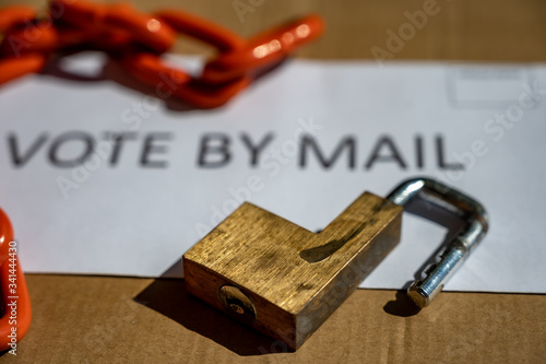 Lock and chain resting on an envelope for vote by mail ballot for election security.