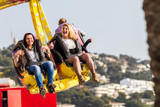 Fototapeta Londyn - young people enjoying a day in the amusement park, attraction with happy face and smiling happy