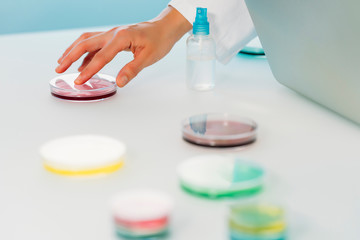  Close up of a Female hand scientist working in a laboratory with laptop and Petri dish investigating the COVID-19. Microbiological laboratory.