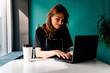© Iryna - Beautiful young college student working in a cafe on a laptop