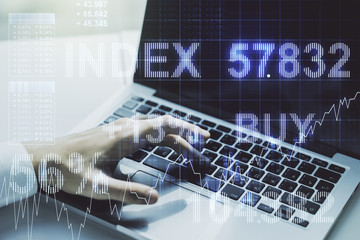 Multi exposure of abstract financial graph with hand typing on laptop on background, financial and trading concept