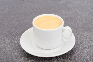 Canvas Print - White cup espresso with foam on gray stone background.