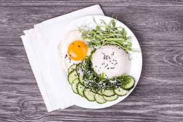 Wall Mural - Rice with cucumber, scrambled eggs, microgreen and Japanese wakame seaweed salad.