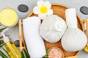 Sticker - Spa massage Aromatherapy body care background. Spa herbal balls, cosmetics, towel and tropical leaves on gray concrete table. Top view, flat lay, overhead, copy space. Beauty and health care concept