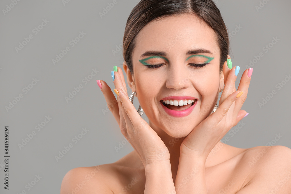 Young woman with beautiful manicure on grey background