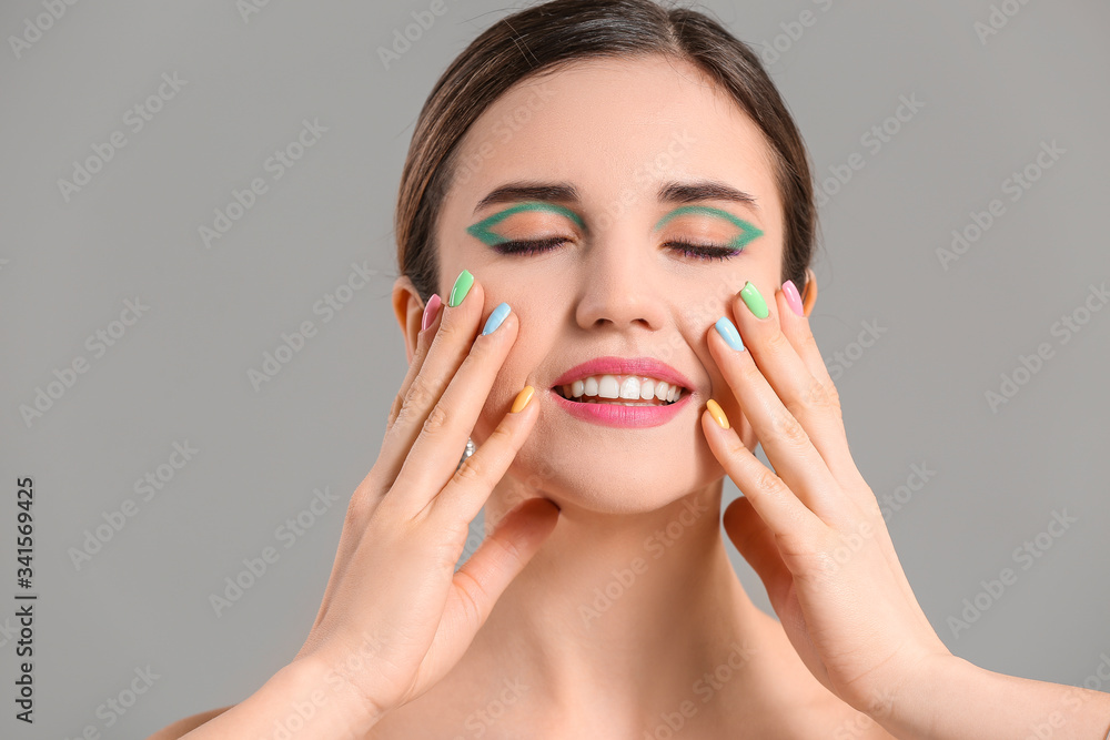 Young woman with beautiful manicure on grey background