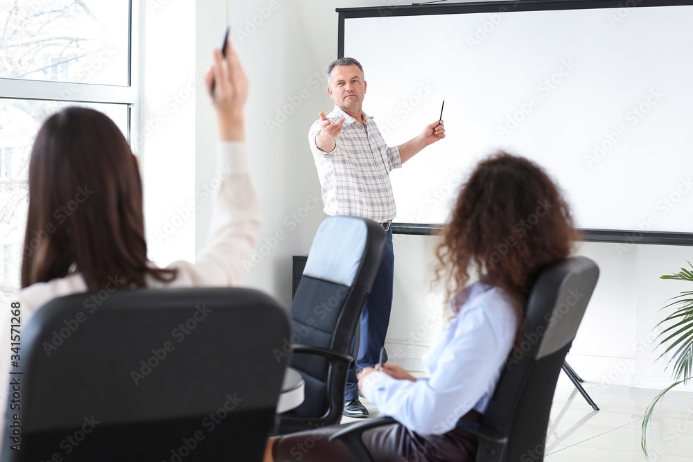 Mature businessman giving presentation during meeting in office