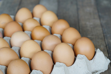 Wall Mural - chicken eggs in egg box on wooden background