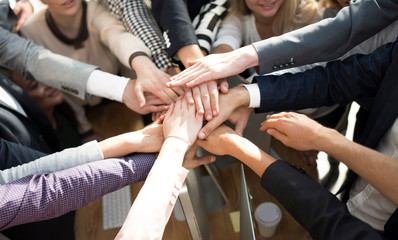 close up. group of young business people putting their palms together.