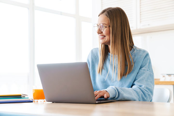 Sticker - Image of cheerful charming woman smiling while working with laptop