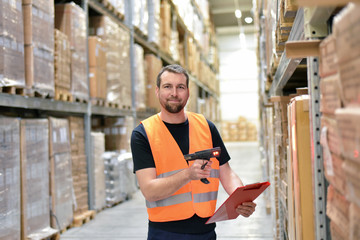 Wall Mural - Warehouse worker scans parcels in the warehouse of a forwarding company for transport