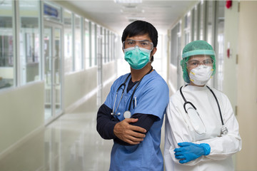 Covid-19  situation: portrait of a Asian young man and woman nurse/ Doctor wearing Personal protective Equipment(PPE) and standing with they arms crossed