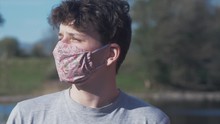 Young Man Puts On Homemade Flower Pattern Corona Virus Cotton Mask CLOSE UP