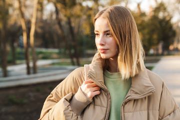 Canvas Print - Portrait of young serious woman posing and looking aside while walking