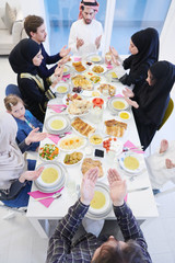 Wall Mural - traditional muslim family praying before iftar dinner