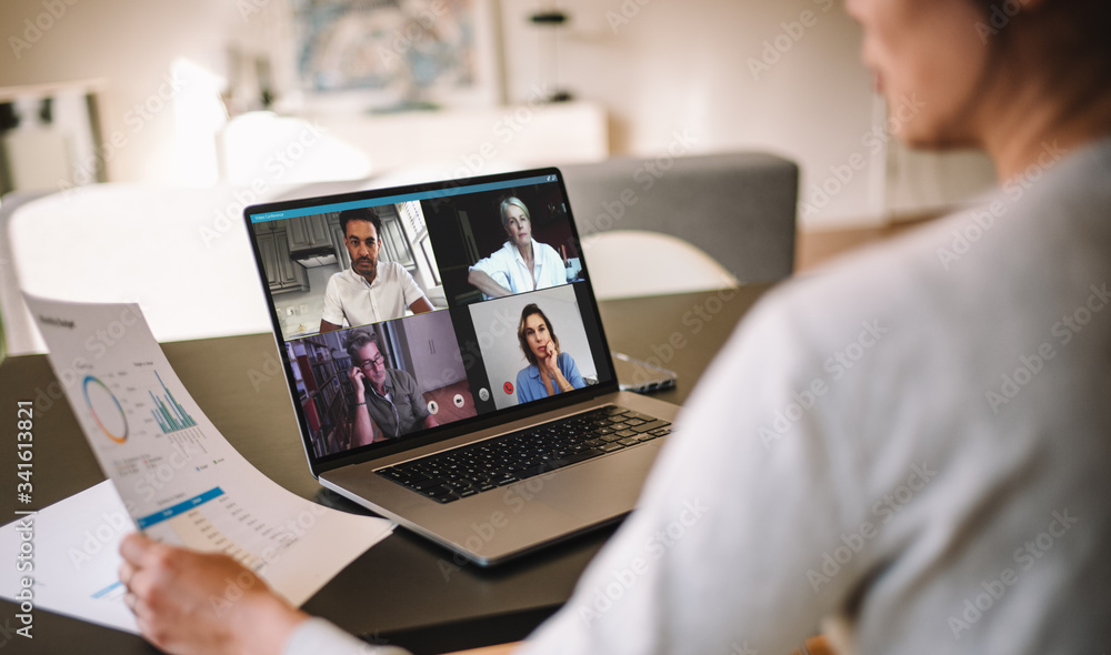 Woman discussing business with team over a video conference - obrazy, fototapety, plakaty 