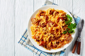 Wall Mural - Cabbage stew with sausages on a white plate