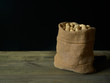 © JuanFrancisco - Peanuts in cloth sack on rustic table