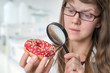 Scientist examines a donut with magnifying glass