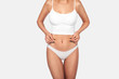 © Alexplanb - Young, healthy and beautiful blonde woman in white lingerie. Sport, fitness, diet, weight loss and healthcare concept. Slim female belly, girl holding her skin for cellulite check.