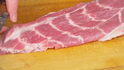 Wall Mural - Sliced raw pork on meat on a wooden cutting board