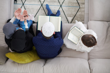 muslim family reading Quran and praying at home top view