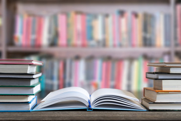 Books and textbook on wooden desk in library selective focus , Piles of books on reading desk in school with copy space for text.World book day and education concept.