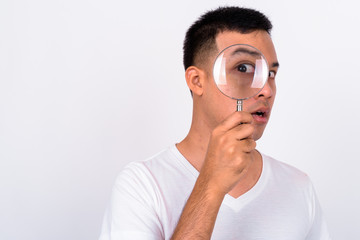 Wall Mural - Face of young Asian man using magnifying glass