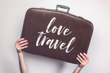 Wall Mural - Love travel message on a vintage travel suitcase