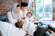 Muslim families with their children are relaxing and joking on the bed during the holidays