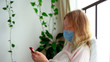 © zayatssv - quarantine for coronavirus epidemic. An infected woman in a mask is chatting via video link on a smartphone.