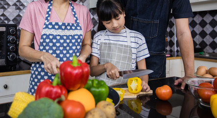 Asian families are cooking  and parents are teaching their daughters to cook in the kitchen at home. .Family activities on holidays and Happy in recreation concept