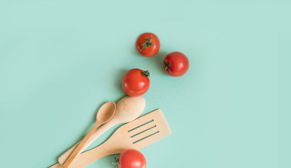 Tree shoulder blades and spoons with ripe tomatoes lie on a light background.