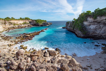 Tropical beach landscape with light blue water and rocks