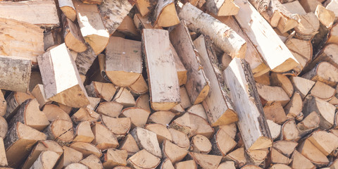 Dry chopped firewood logs in pile stacked outdoor