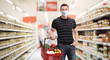 © Ljupco Smokovski - Young man with a medical mask and a shopping basket in a supermarket