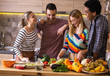 © BalanceFormCreative - Group of friends preparing vegetarian meal.They preparing food and making fun in the kitchen.