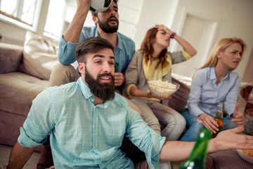 Wall Mural - Young friends drinking beer and watching tv at home