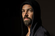 Moody portrait of a bearded man in a hood